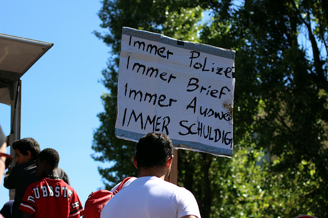 Plakat mit der Aufschrift: "Immer Polizei, immer Brief, immer Ausweis, immer Schuld" bei Protesten gegen rassistische Kontrollen.